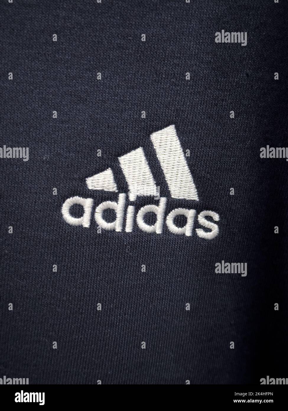 Novi, Michigan, USA - OCT 02, 2022: Adidas original logo white color on dark or black fabric Stock Photo