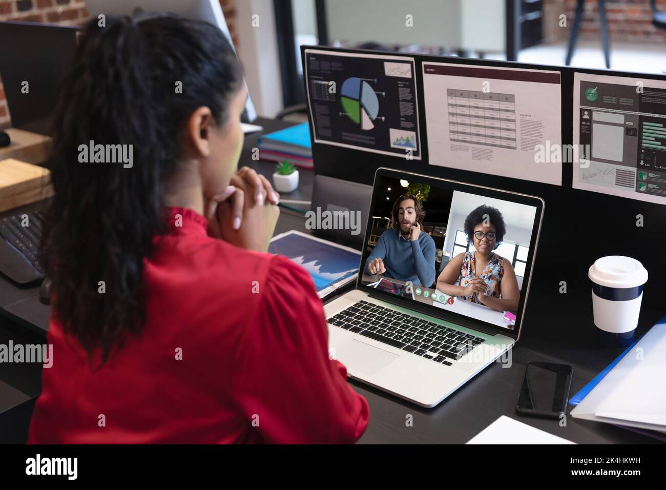 Caucasian woman in office having video call with diverse colleagues ...