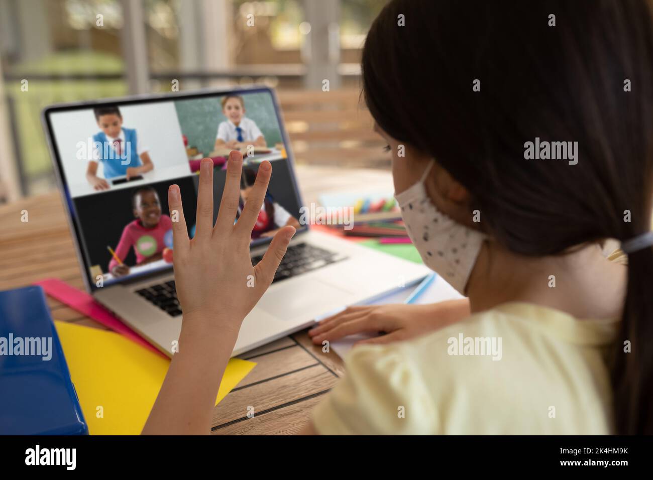 Videoconference Mask Female student wearing face mask having a video conference with ...