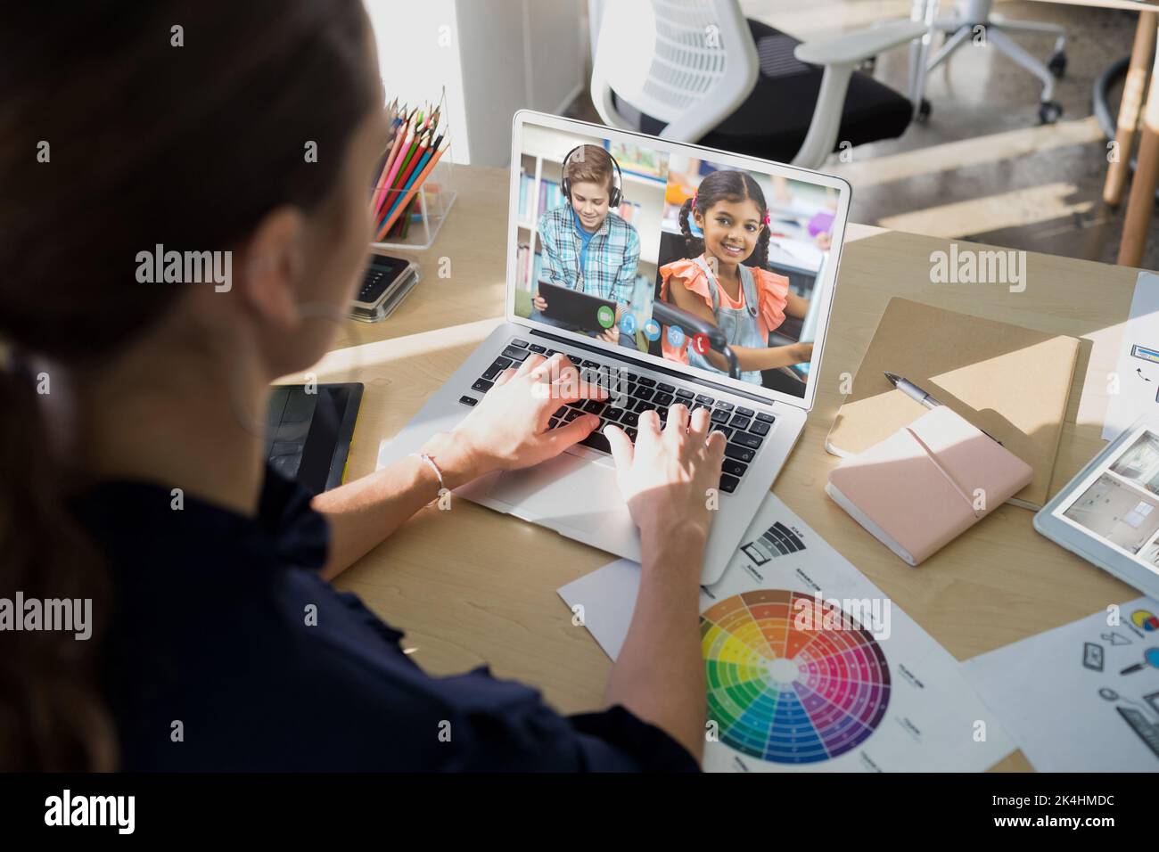 Female teacher having a video conference with male and female students ...