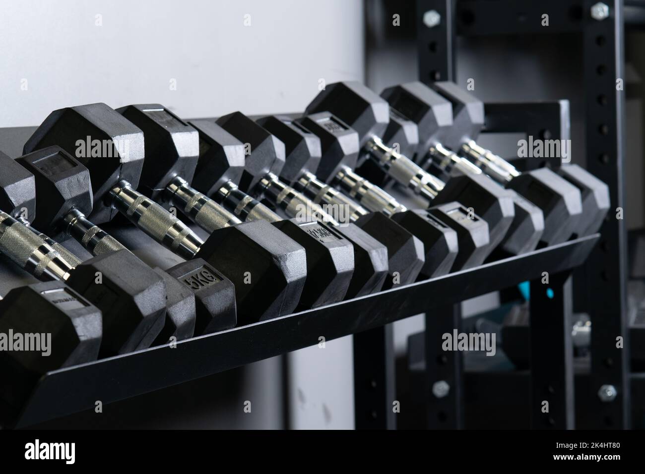 Dumbbell home wall blurry gym set storage rig sport, for accessories gear from black for exercise active, power hard. Lifting , Stock Photo
