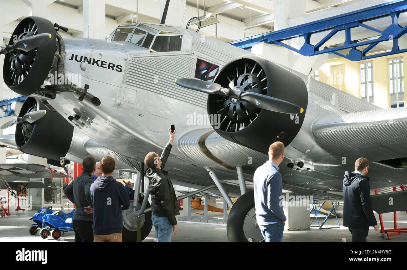 29 September 2022, Saxony-Anhalt, Dessau-Roßlau: Visitors to the 'Hugo Junkers' Museum of Technology stand in front of a restored Junkers Ju 52/3m. The aircraft, also known as 'Aunt Ju,' is the special exhibit in the museum. It sank during World War II after an emergency landing on the ice in Lake Hartvik near Narvik and was raised relatively intact in 1986. In 1995, she returned to Dessau and was restored by members of the Förderverein Technikmuseum Hugo Junkers. The museum in Dessau-Roßlau is dedicated to the aircraft designer and entrepreneur Hugo Junkers. The museum, which opened in 2001 o Stock Photo