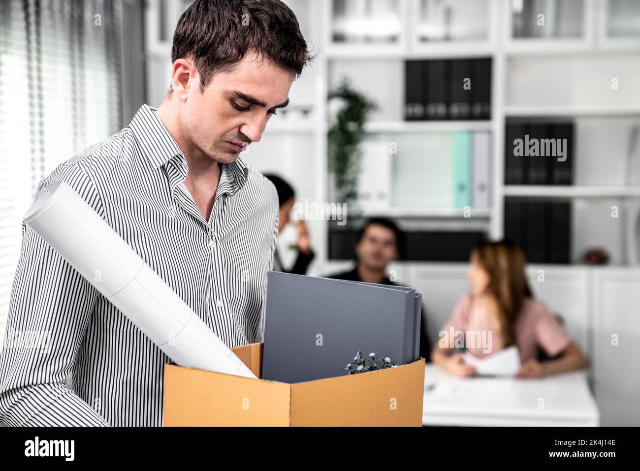 Depressed and disappointed employee packing his belongings after being fired for not being