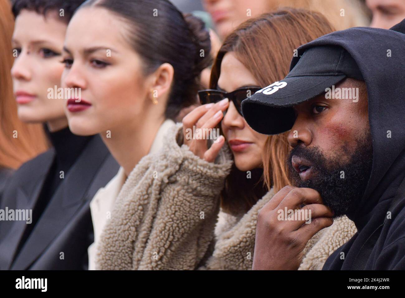 Olivia Rodrigo, guest talking with Kanye West, attend the Givenchy show