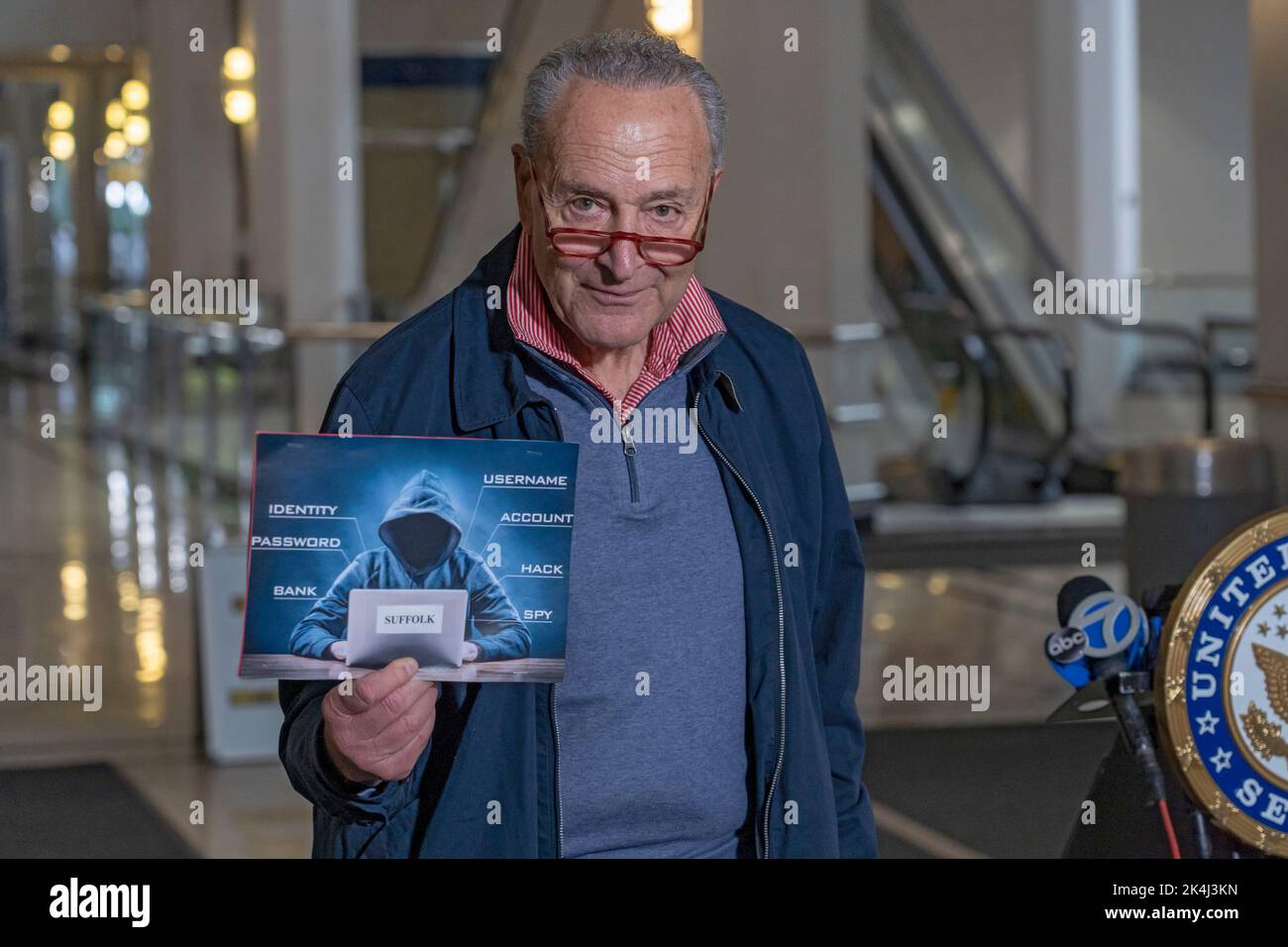 NEW YORK, NY – OCTOBER 02: Senate Majority Leader, U.S. Senator Chuck Schumer (D-NY) holds up a sign with a symbolic hacker on it on October 2, 2022 in New York City. New York Senator Chuck Schumer is calling on the federal government to release more information about recent data breaches, and to increase their efforts to protect consumers from cyber security breaches and investigate those responsible for such hacks. Credit: Ron Adar/Alamy Live News Stock Photo