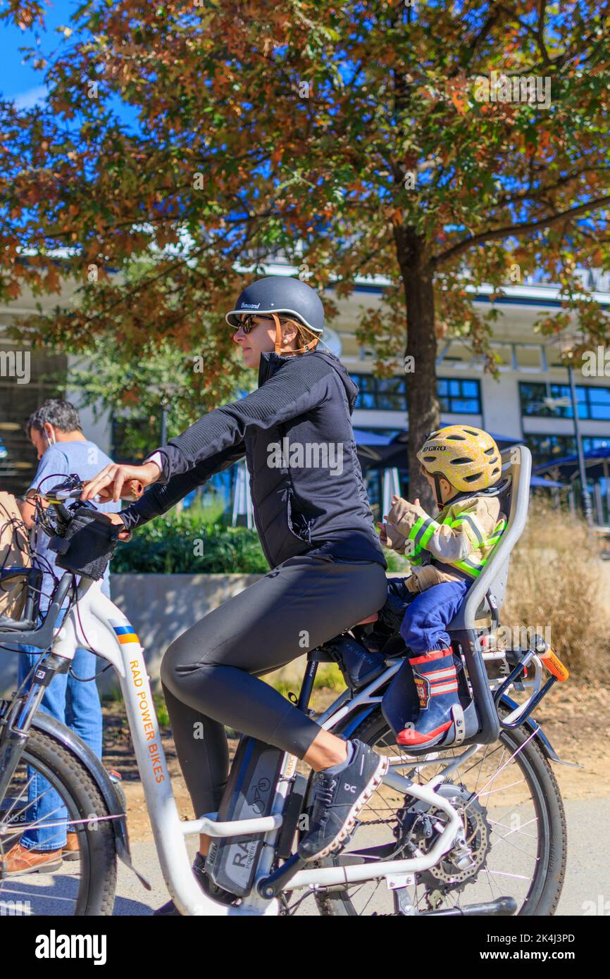 Atlanta, Georgia, November 14, 2020: Child with helmet on riding on the back of a bicycle. Stock Photo