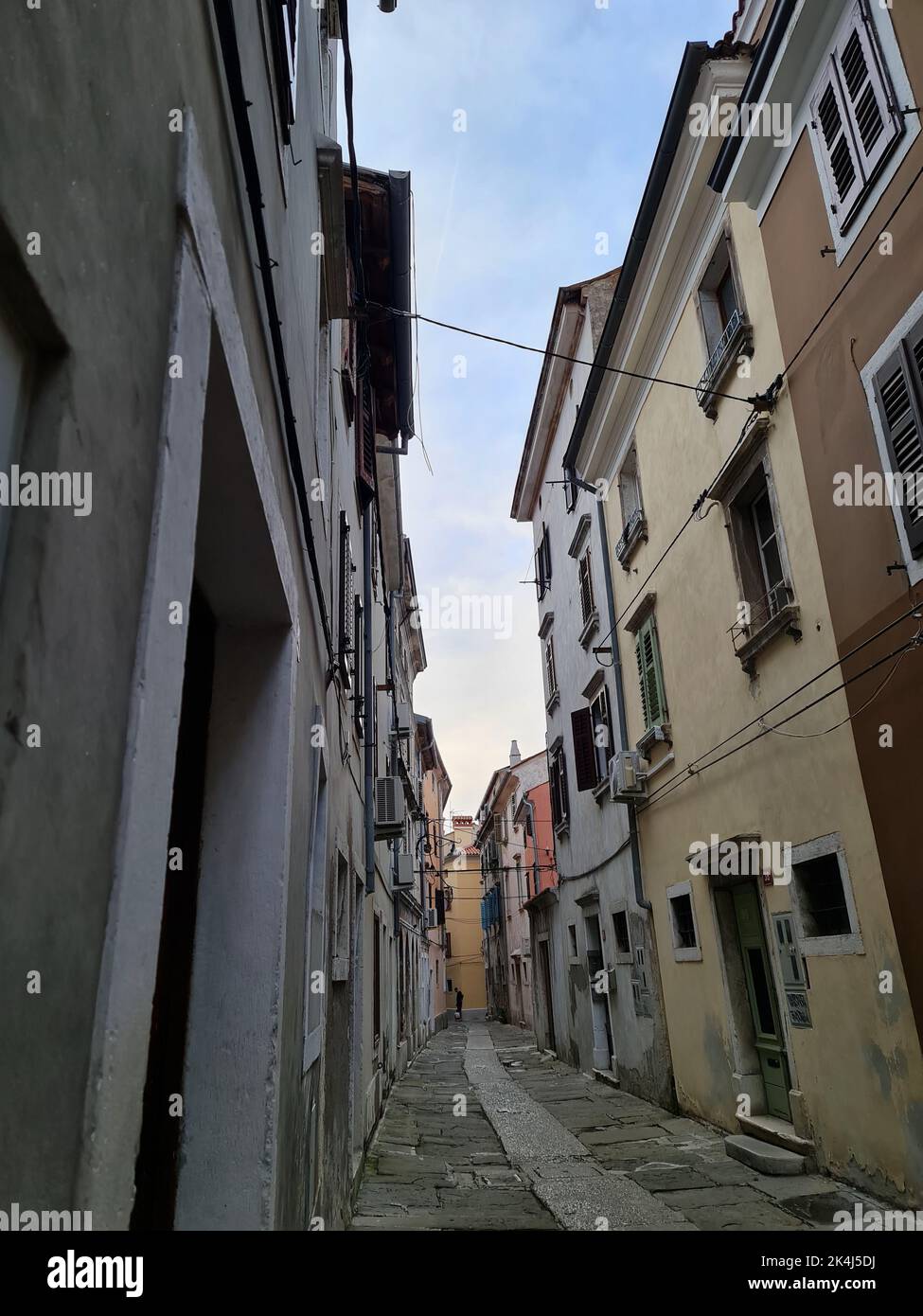 A vertical shot of a narrow walking path between the old buildings ...
