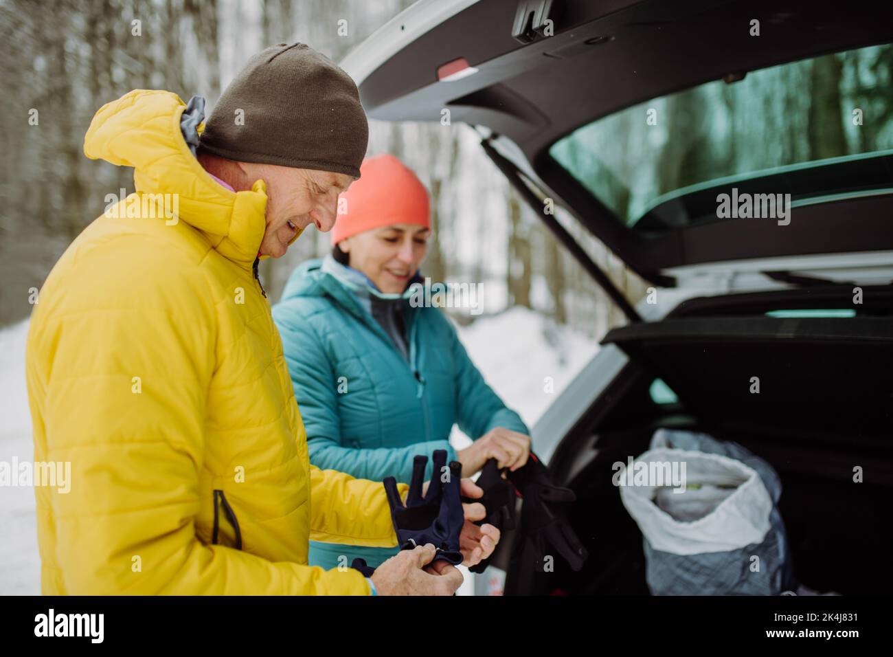 Senior couple near car trunk preparing for winter hiking. Stock Photo