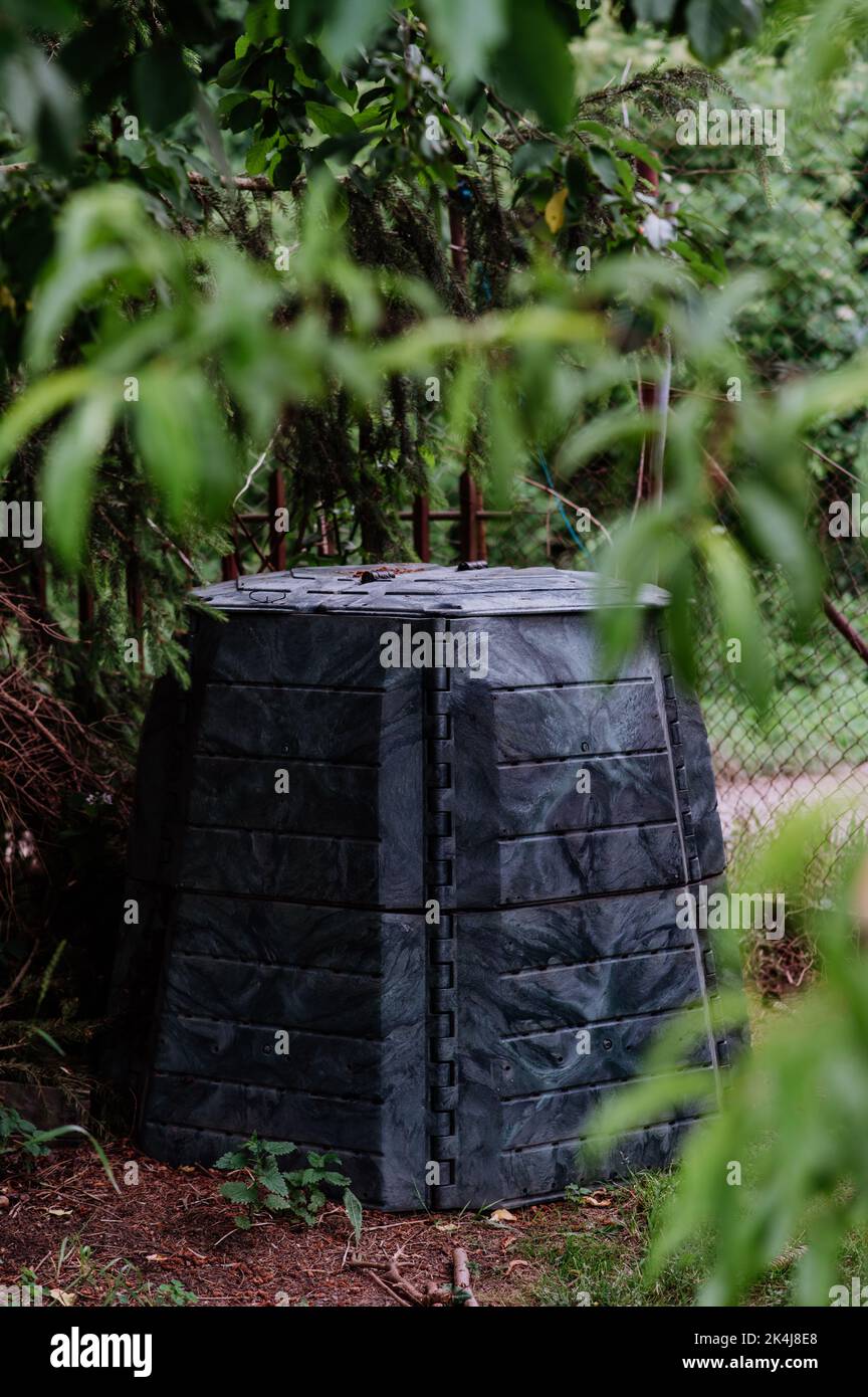 Plastic compost box in garden. Concept of waste separation, reusing of waste, fertilizer. Stock Photo