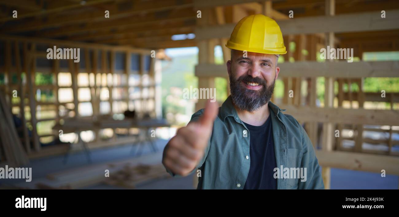 Portrait of construction worker smiling and looking at camera, diy eco-friendly homes concept. Stock Photo