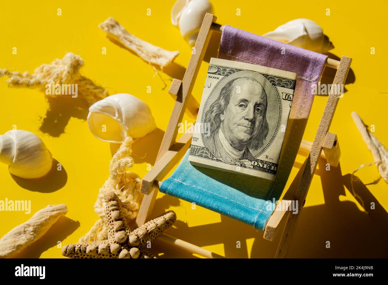Rolled Up Hundred Dollar Banknote On Miniature Deck beach Chair ...