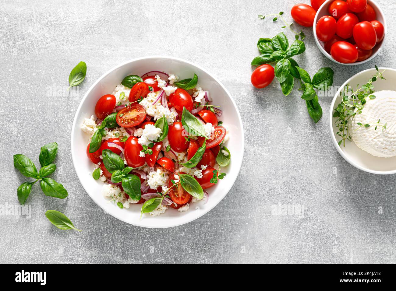 Salad with tomato, italian ricotta cheese and basil, top view Stock Photo