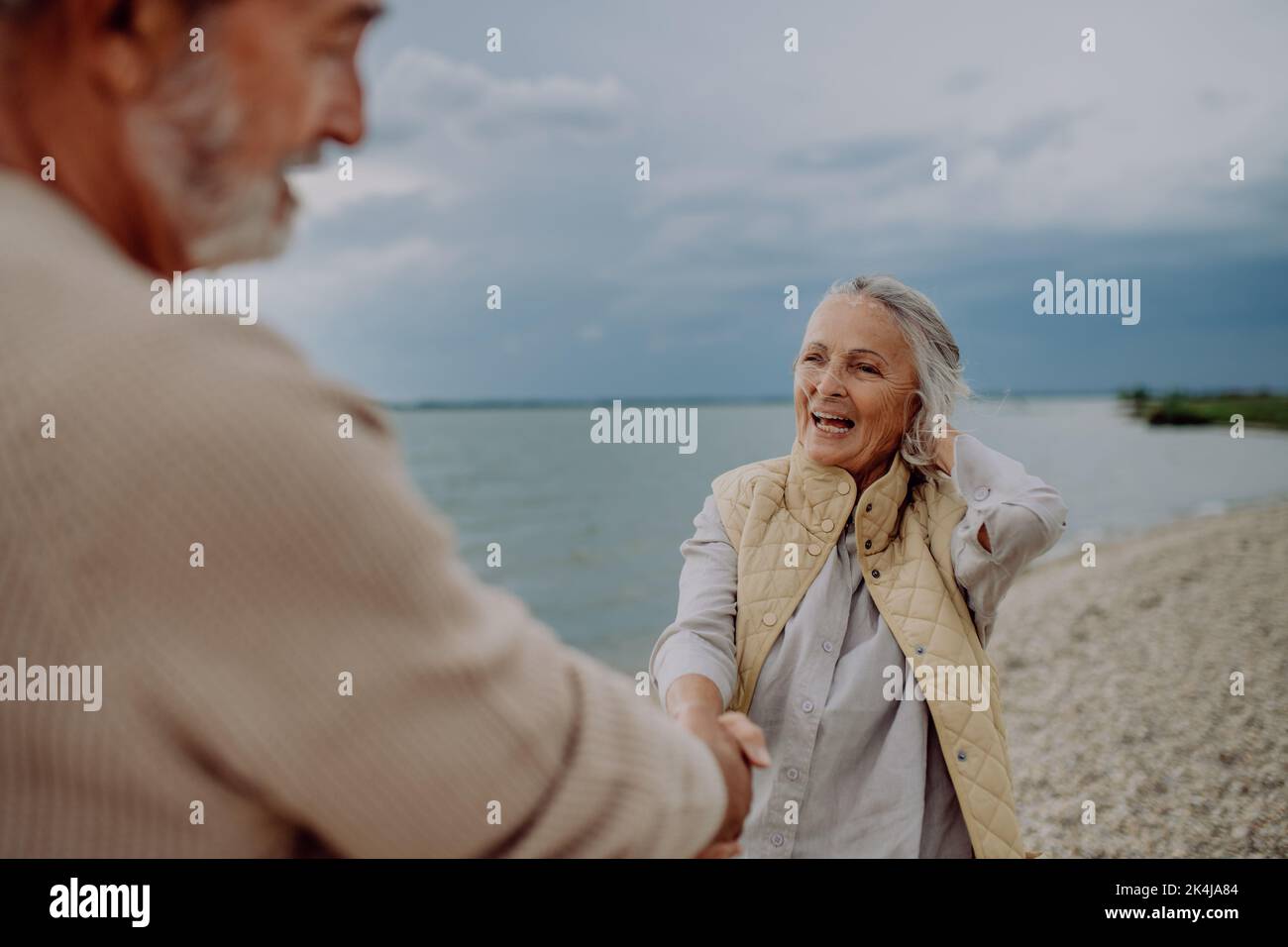 Happy senior couple relaxing and having romantic moment at the autumn sea. Stock Photo