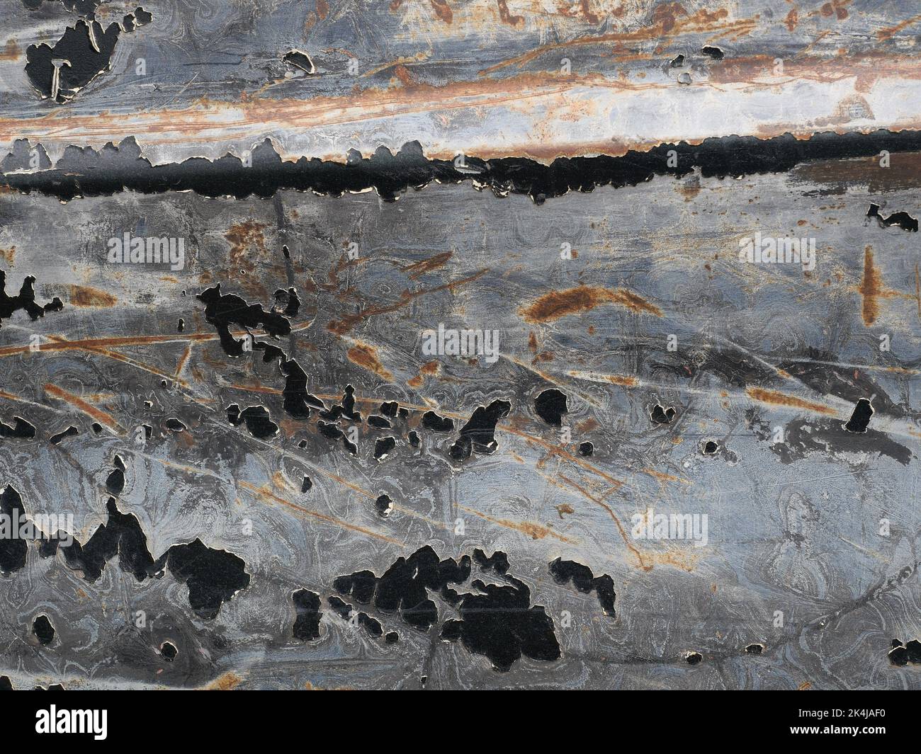 Brown rust stain on the black with blue with green with gray and silver color surface of the sheet metal , Cracked and flaking surfaces Stock Photo