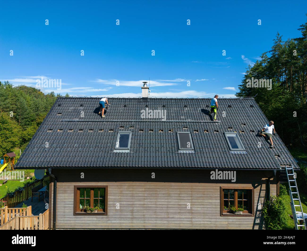 High angle view of men worker installing solar photovoltaic panels on roof, alternative energy, saving resources and sustainable lifestyle concept. Stock Photo