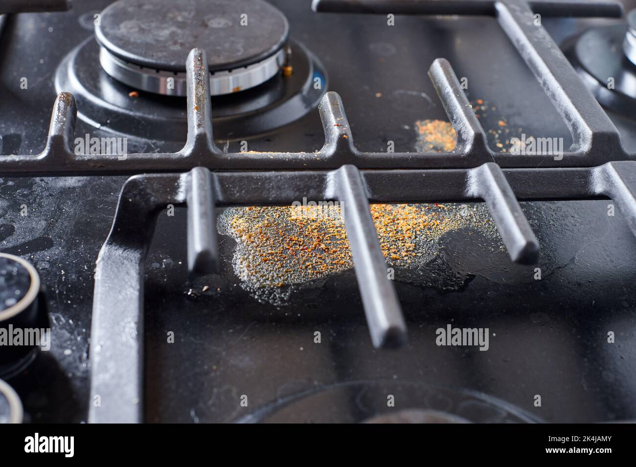Unclean dirty kitchen black stove after soup boil over, dried food