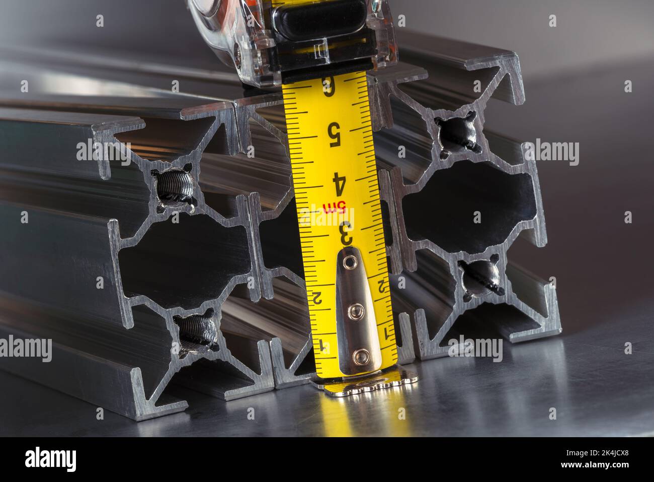 Measuring tape with metal profiles close-up, tool and component of construction industry Stock Photo