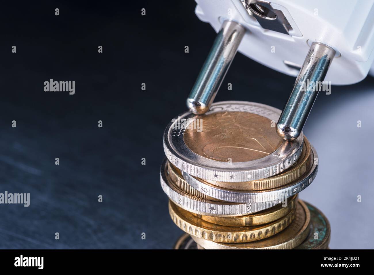 Pile of euro coins and electrical socket, concept of increasing energy prices Stock Photo