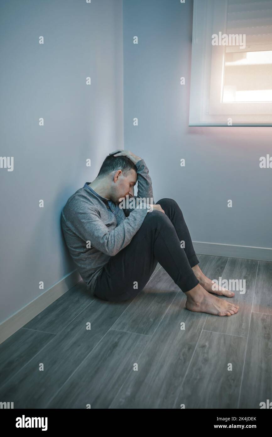 Man with problems resting sitting on the floor Stock Photo