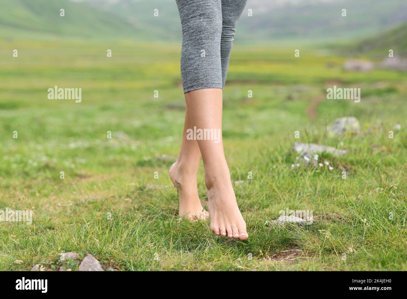 Close up of a bareffot sportswoman feet walking on the grass in the mountain Stock Photo