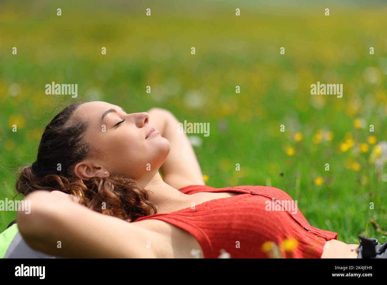 Relaxed woman resting lying in a field in the mountain on summer Stock Photo