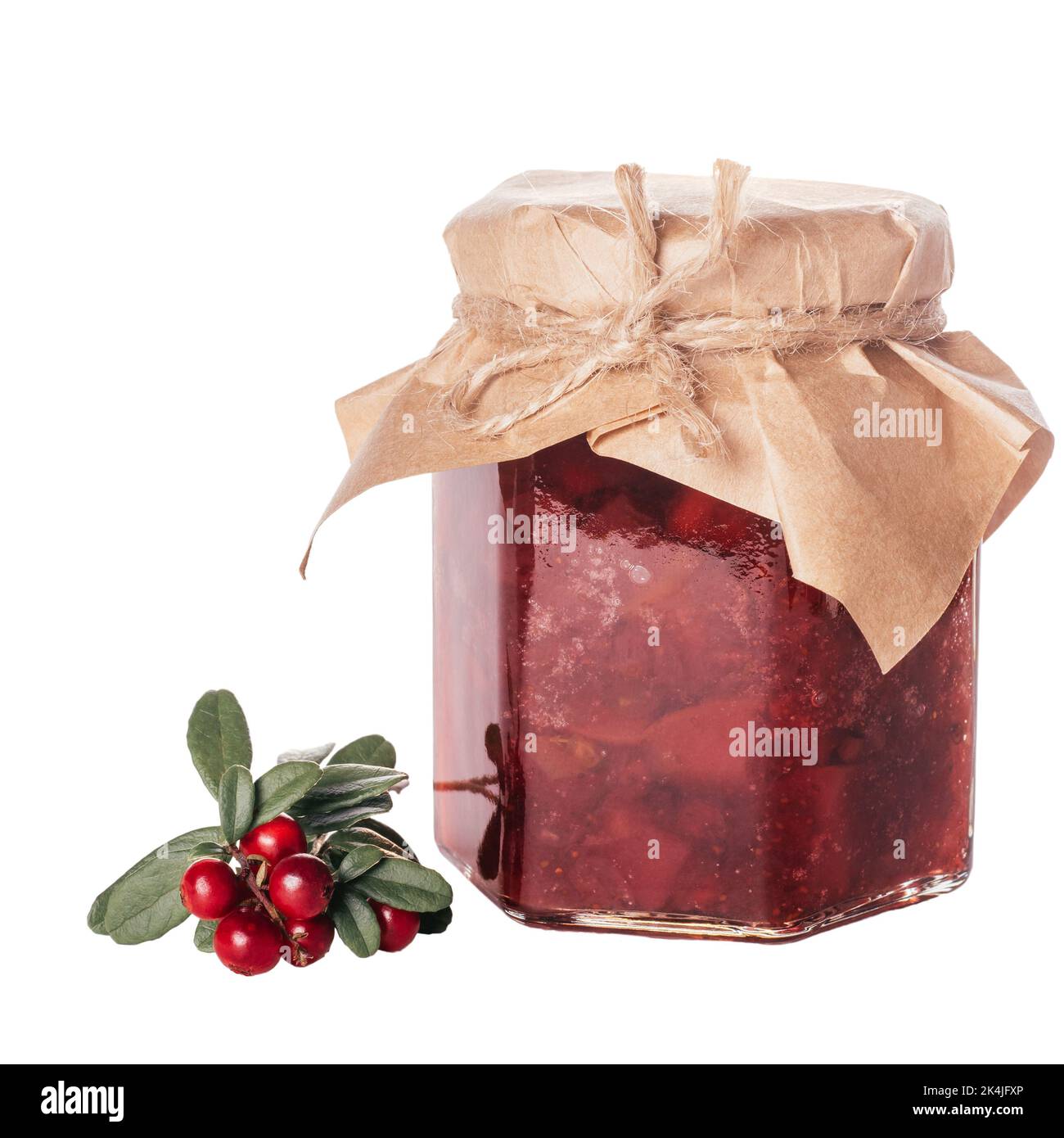 Jar of homemade lingonberry and pear jam with craft paper on lid next to fresh lingonberries isolated on white background. Autumn homemade Stock Photo