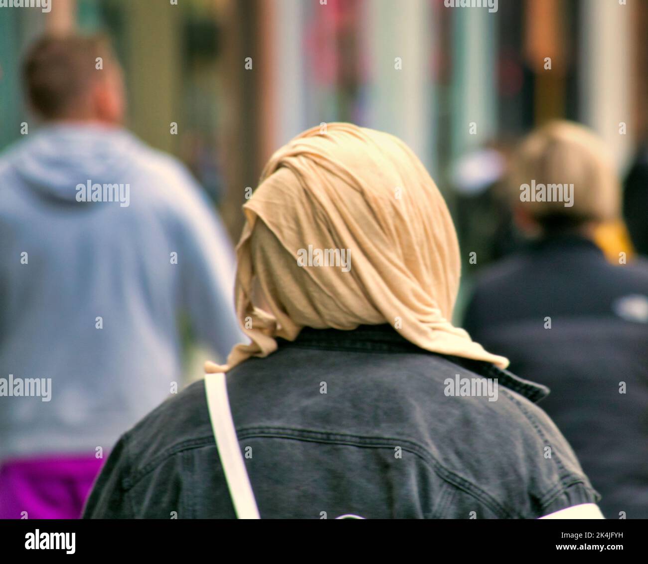 Muslim woman wearing hijab scarf from behind Glasgow, Scotland, UK Stock Photo