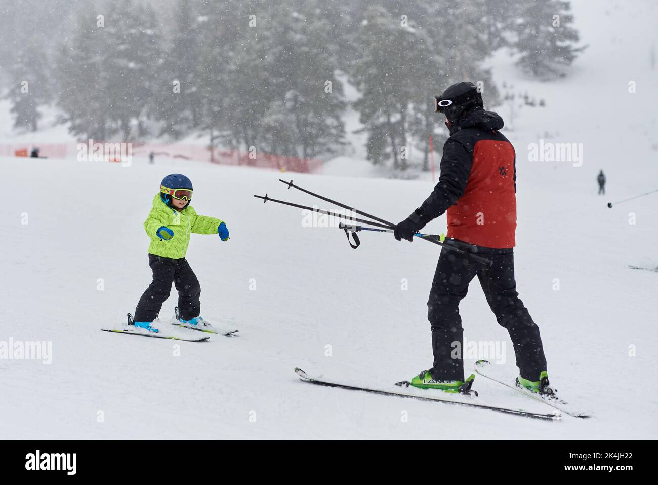 Ski instructor teaches the child to ski on the slope. Stock Photo