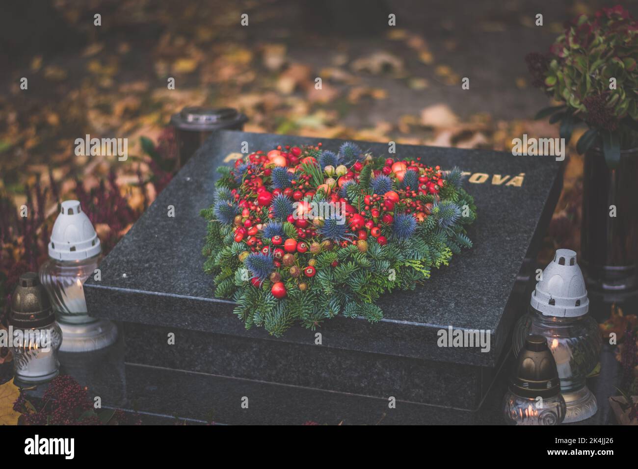 burning candle and chrysanthemum flower decoration on grave in the
