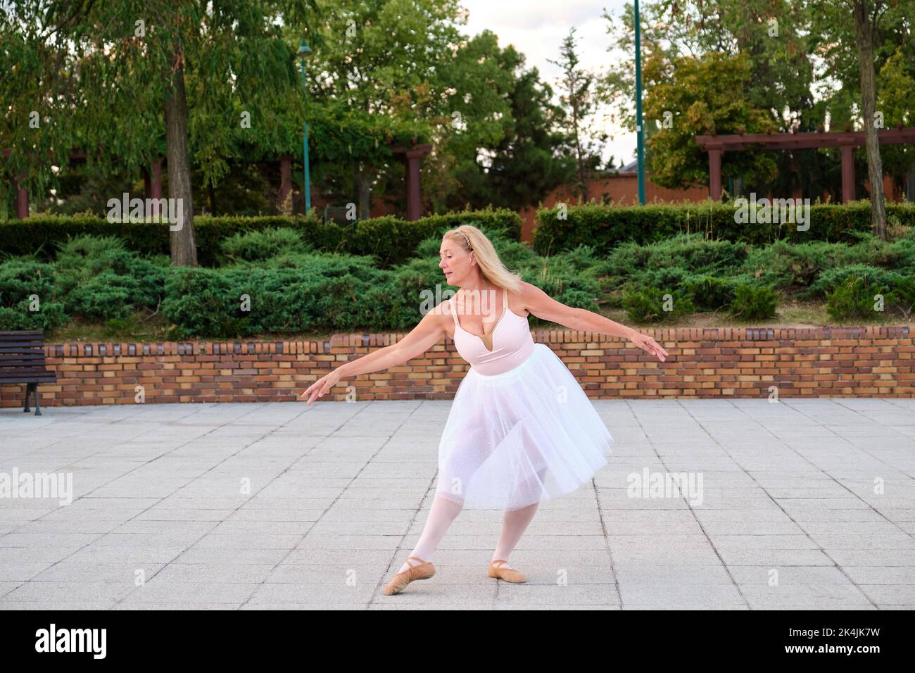 Lady dancing ballet in a park at street. Stock Photo