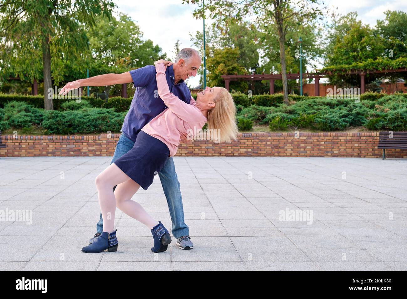 Mature couple dancing tango in a park at street. Stock Photo