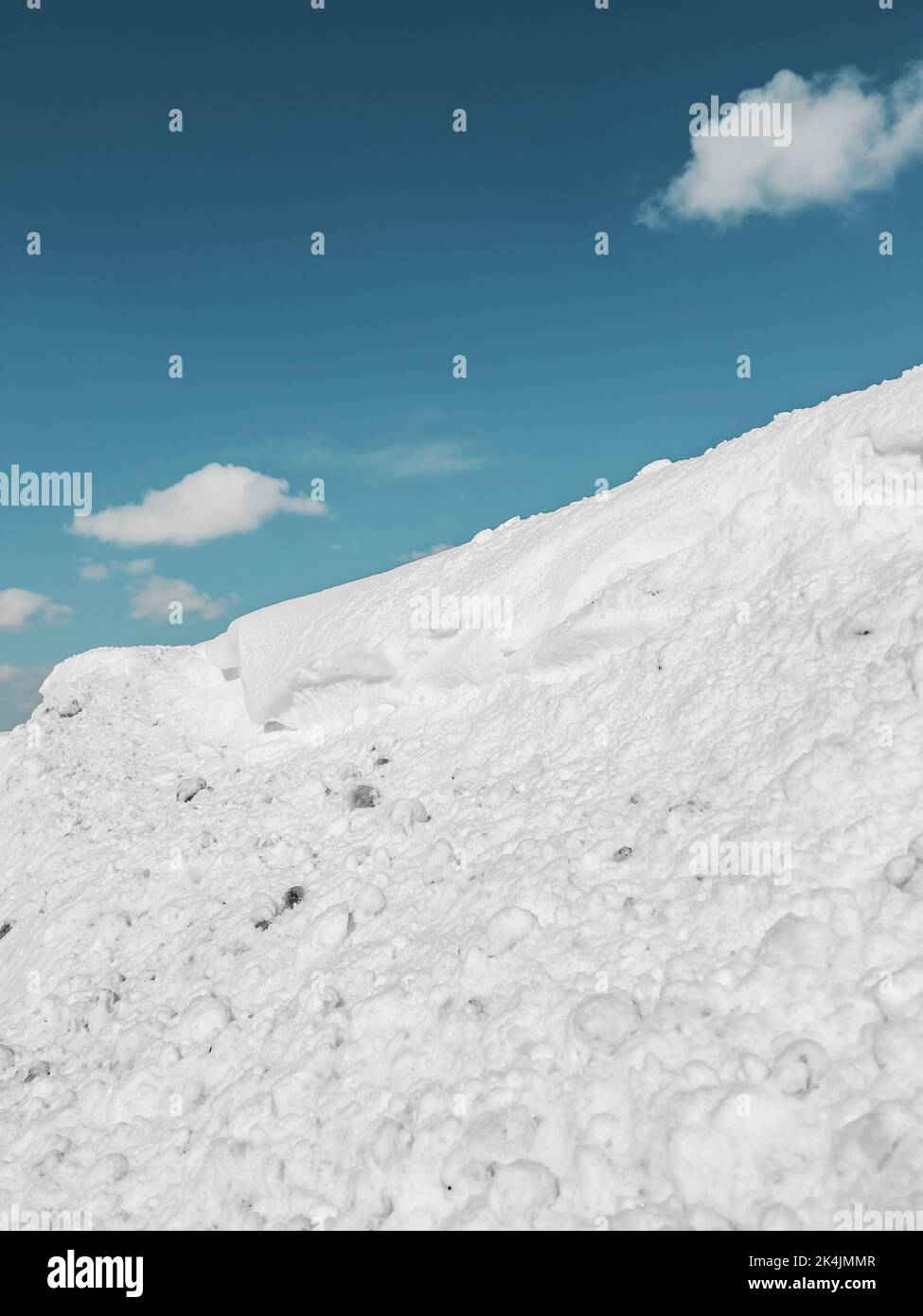 Winter season background, snow on the hill and blue sky with white clouds. Stock Photo