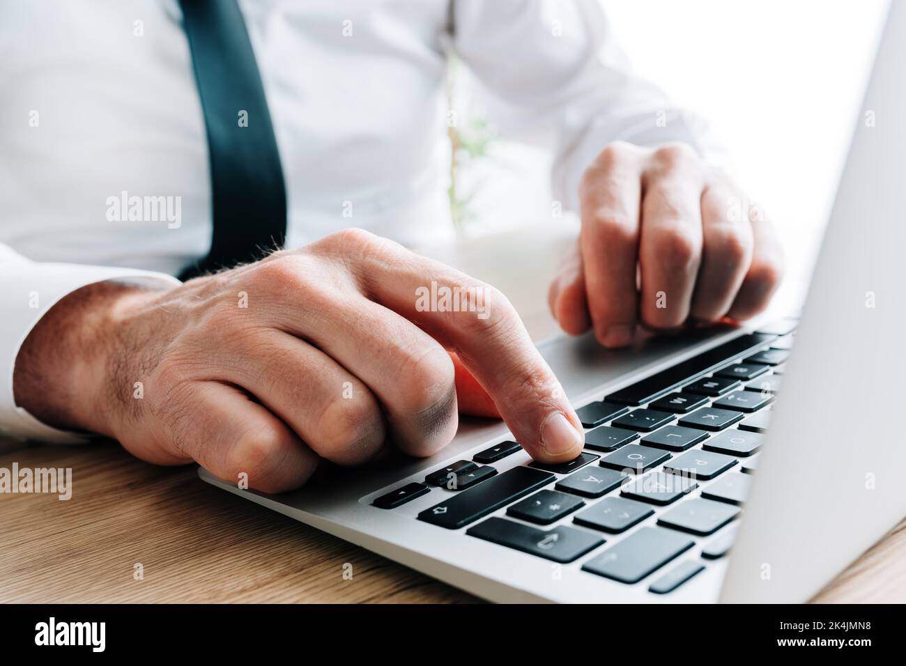 Hands of mature businessman using laptop computer, closeup with selective focus Stock Photo