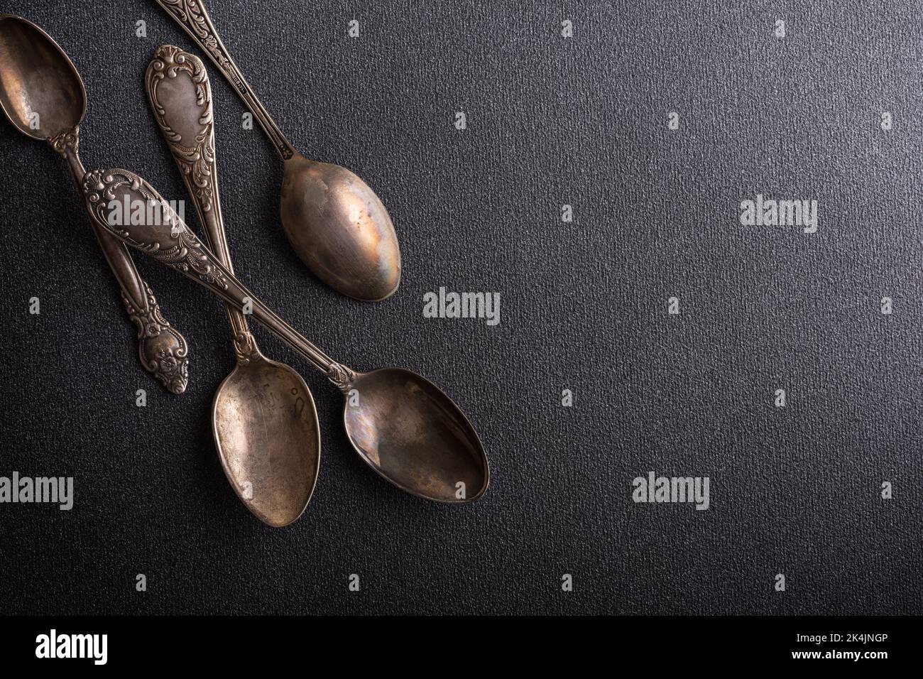 Top view of vintage silver spoons or silverware on dark concrete background with copy space Stock Photo
