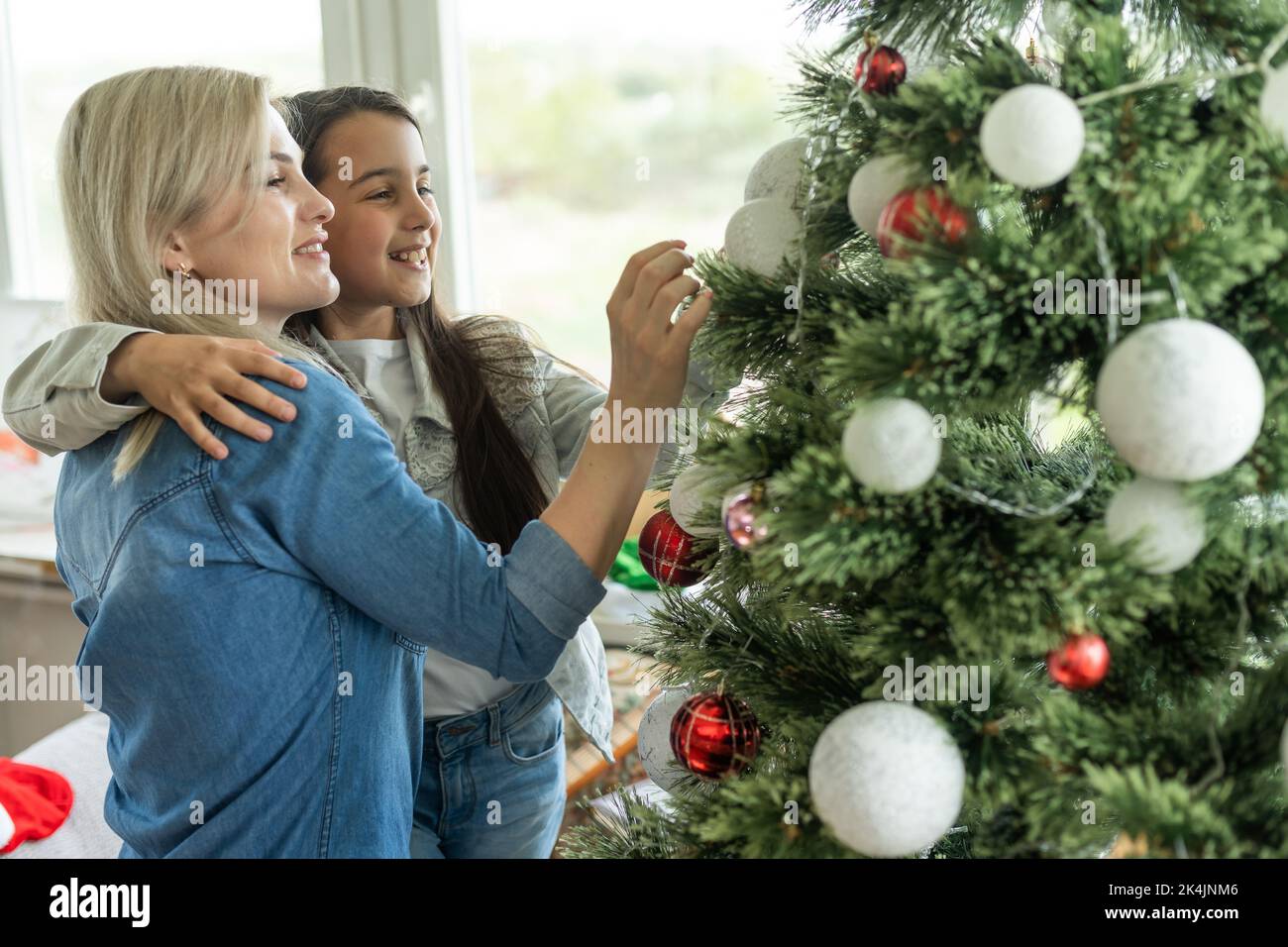 https://c8.alamy.com/comp/2K4JNM6/merry-christmas-and-happy-holidays-cheerful-mother-and-her-cute-daughter-girl-exchanging-gifts-mom-and-little-child-having-fun-near-tree-indoors-2K4JNM6.jpg