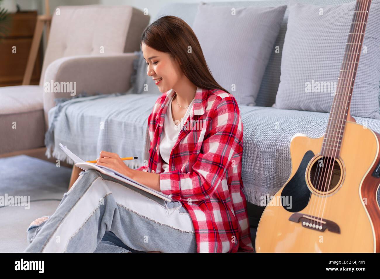 Writing Sign Singer Guitar and singer concept, Young asian woman is composing new song and ...