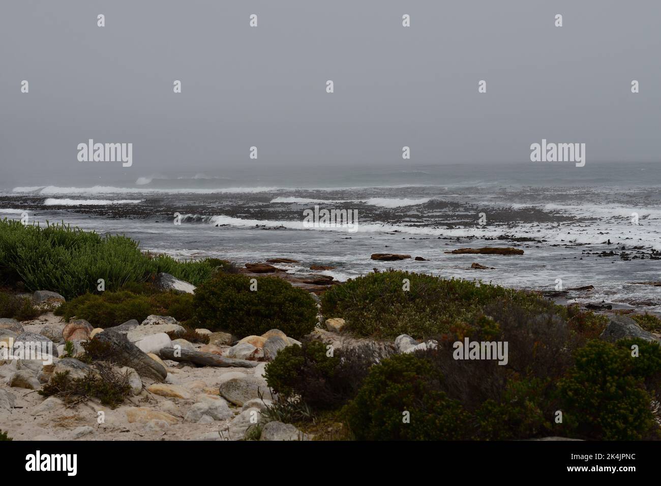 A rocky lakeshore with waves on a cloudy dark day Stock Photo - Alamy