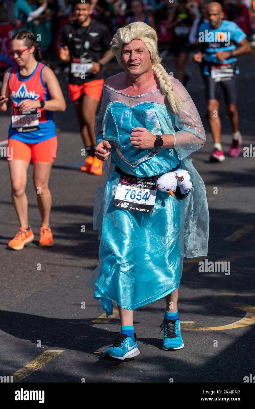 Adrian Maj running in the TCS London Marathon 2022, on Tower Hill road, City of London, UK. Wearing Frozen character Elsa dress costume Stock Photo