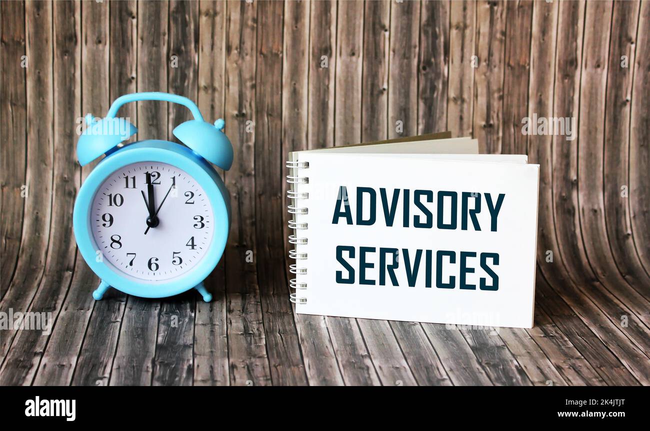 ADVISORY SERVICES text on notepad with clock on wooden background Stock Photo
