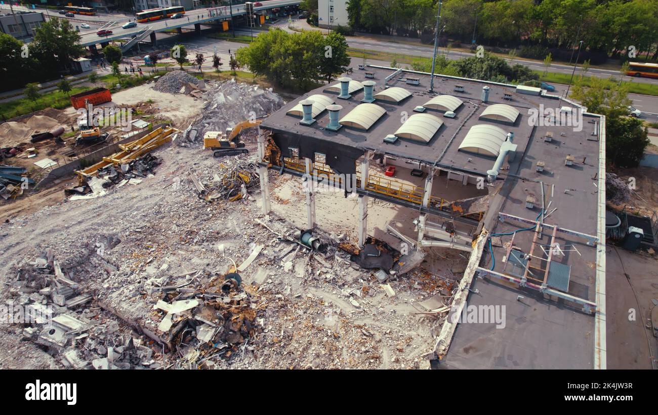 06.08.2022 - Warsaw, Poland - The demolition site. Heavy machinery, excavators destroying a huge old building. Freeing up space for the construction of a new one. Top drone view. High quality photo Stock Photo