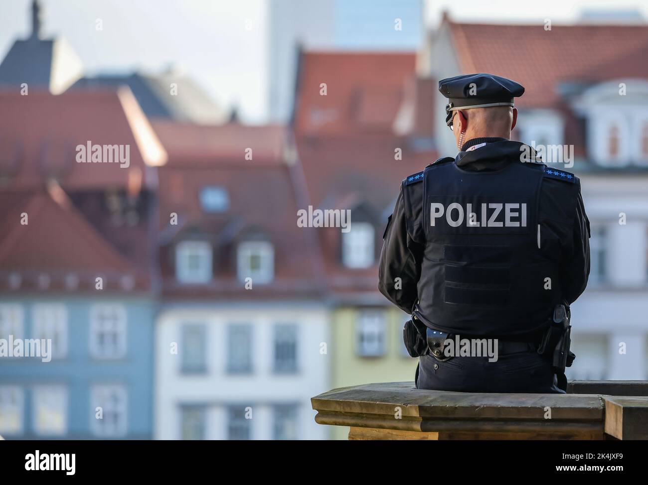 Erfurt, Germany. 03rd Oct, 2022. A police officer observes the action on Cathedral Square during the unity celebrations on October 3. Thuringia holds the presidency of the Bundesrat and is thus the host of the central celebrations for German Unity Day. Credit: Jan Woitas/dpa/Alamy Live News Stock Photo