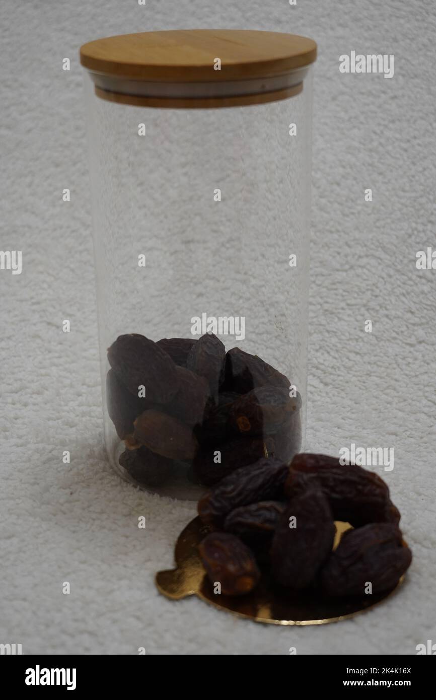 black prunes in glass jar on textured white background Stock Photo Alamy