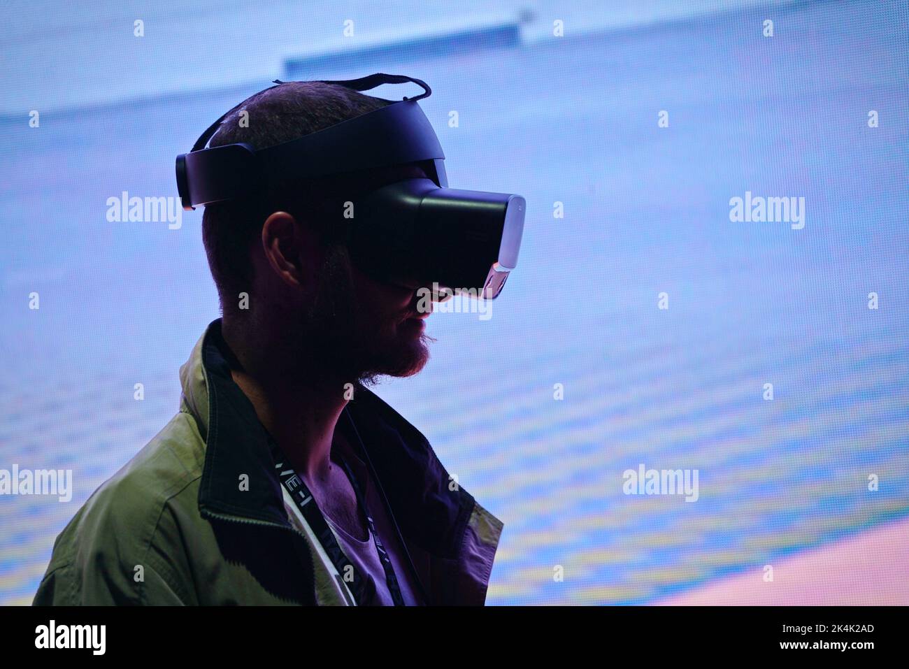 Virtual reality exhibit. Young man wears virtual reality goggles experiences a metaverse encounter. Turin, Italy - September 2022 Stock Photo