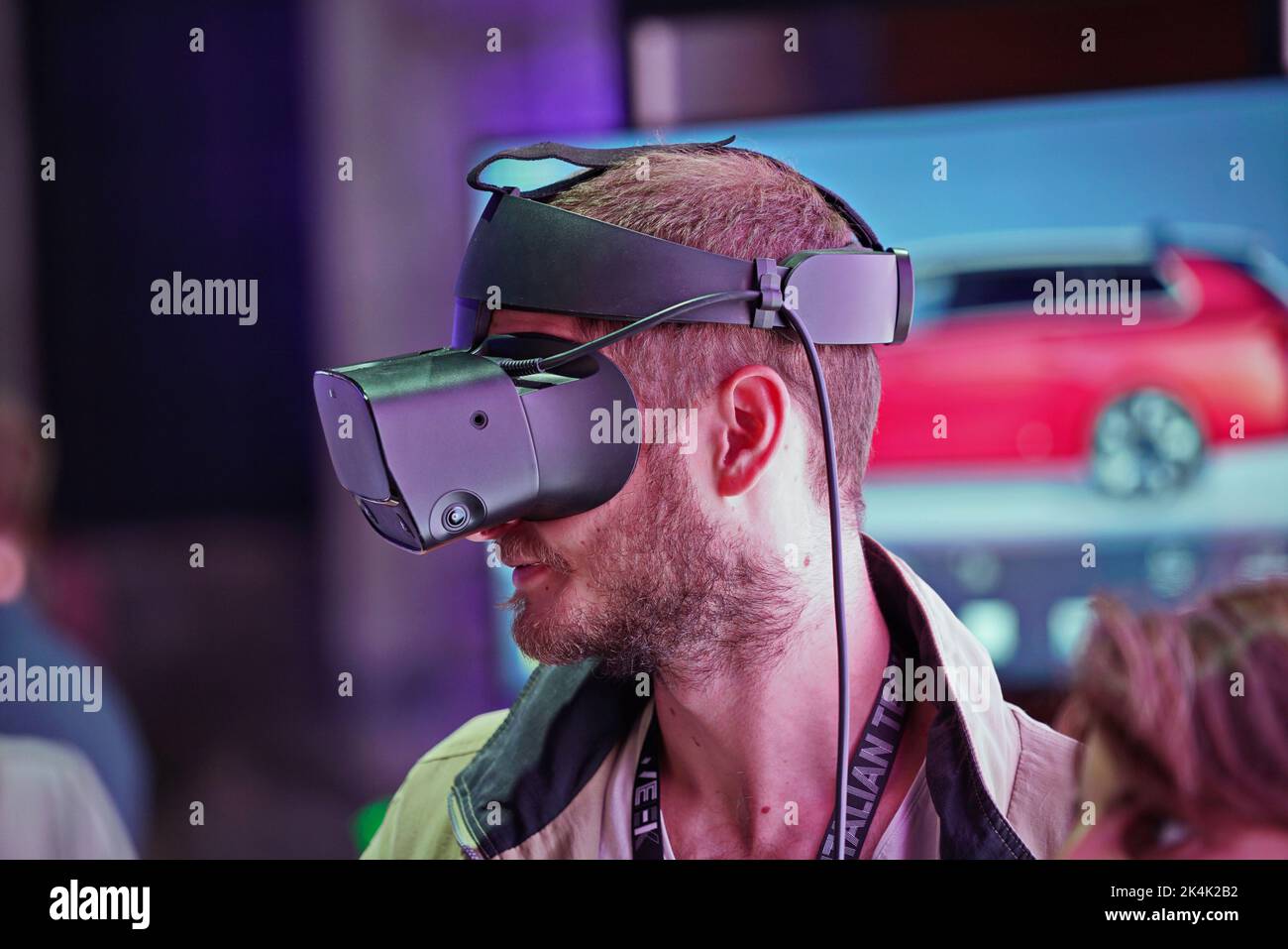 Virtual reality exhibit. Young man wears virtual reality goggles experiences a metaverse encounter. Turin, Italy - September 2022 Stock Photo