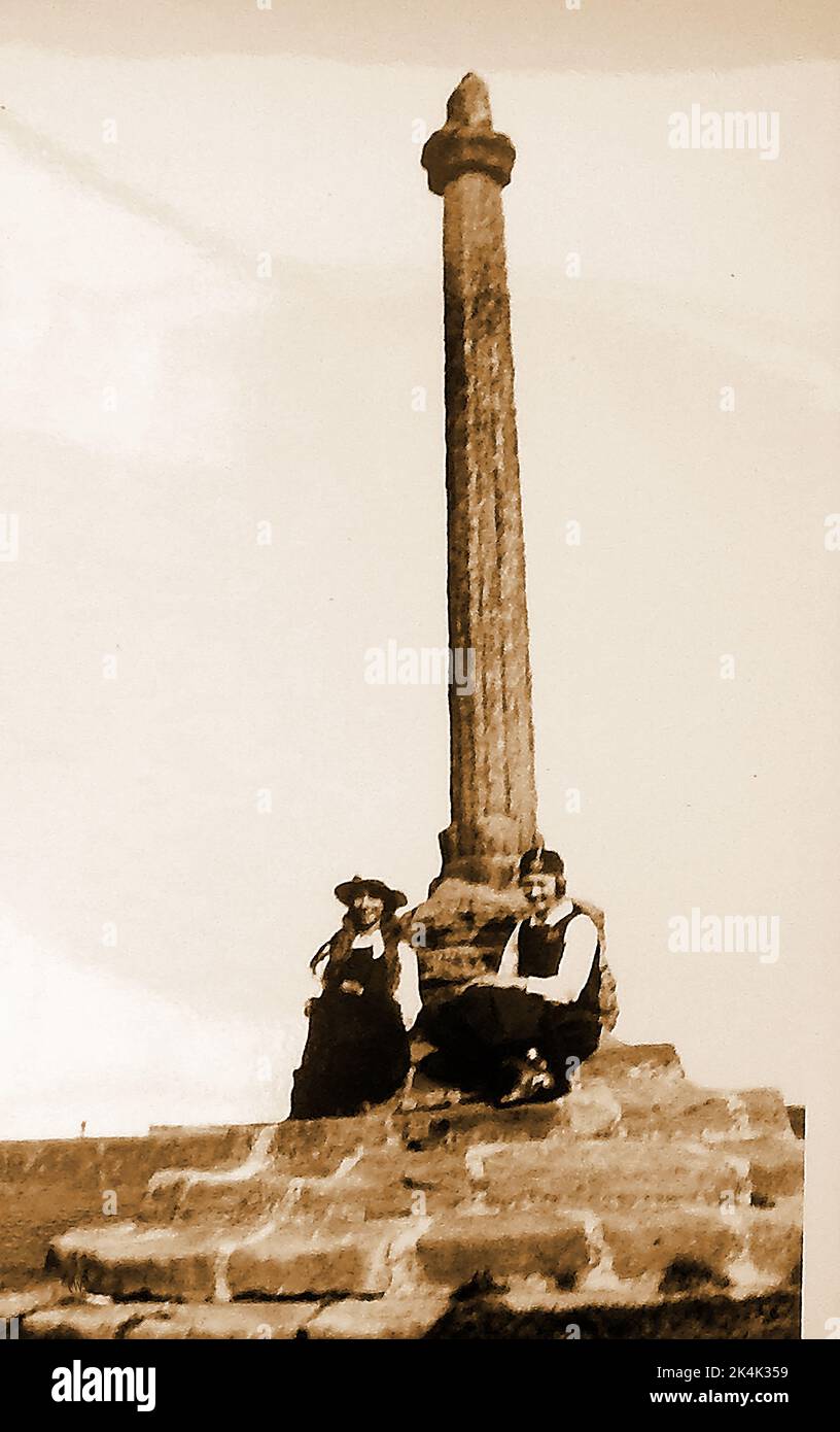 A very early snapshot of two schoolgirls in uniform sitting on the steps of the old market cross near Whitby Abbey, on the abbey plane(abbey plain) Stock Photo