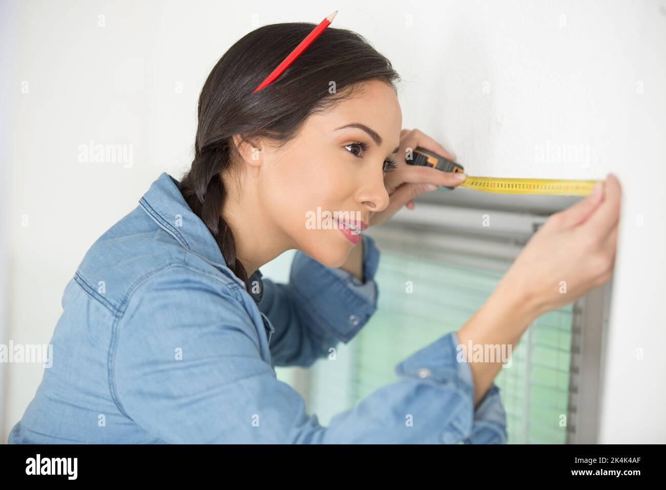 female worker measures a window Stock Photo