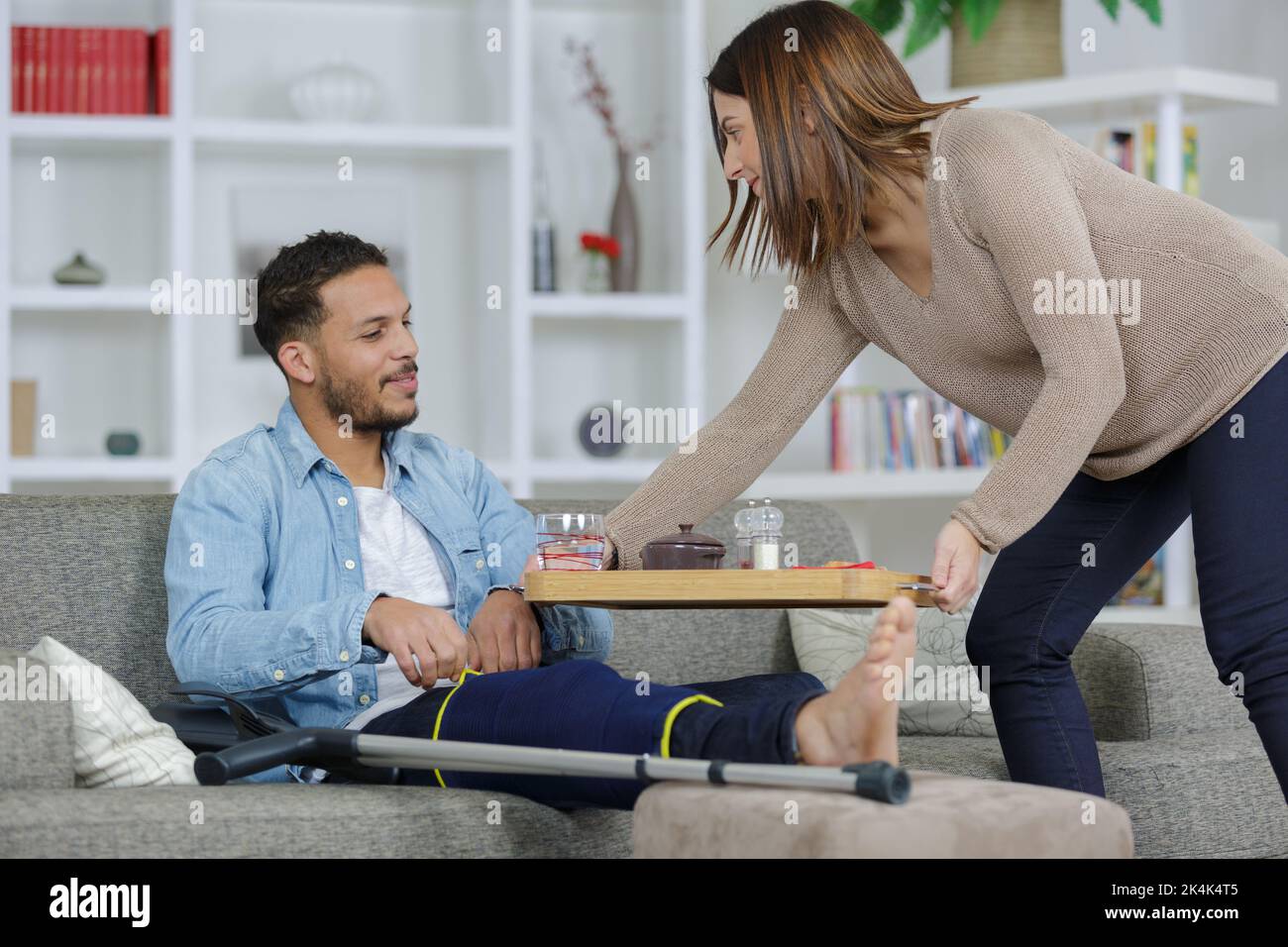 woman serving snack to injured man Stock Photo