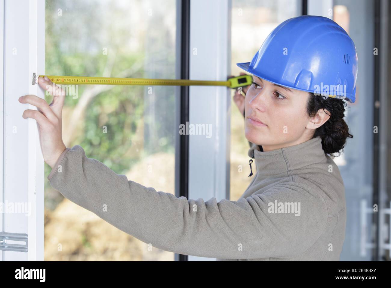 woman measuring a window with tape measure Stock Photo