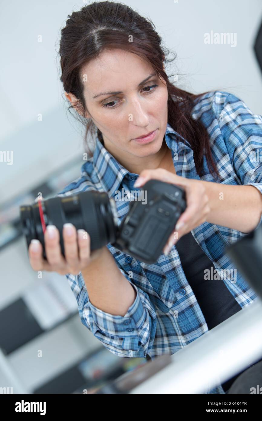 woman assembling lens on to camera body Stock Photo