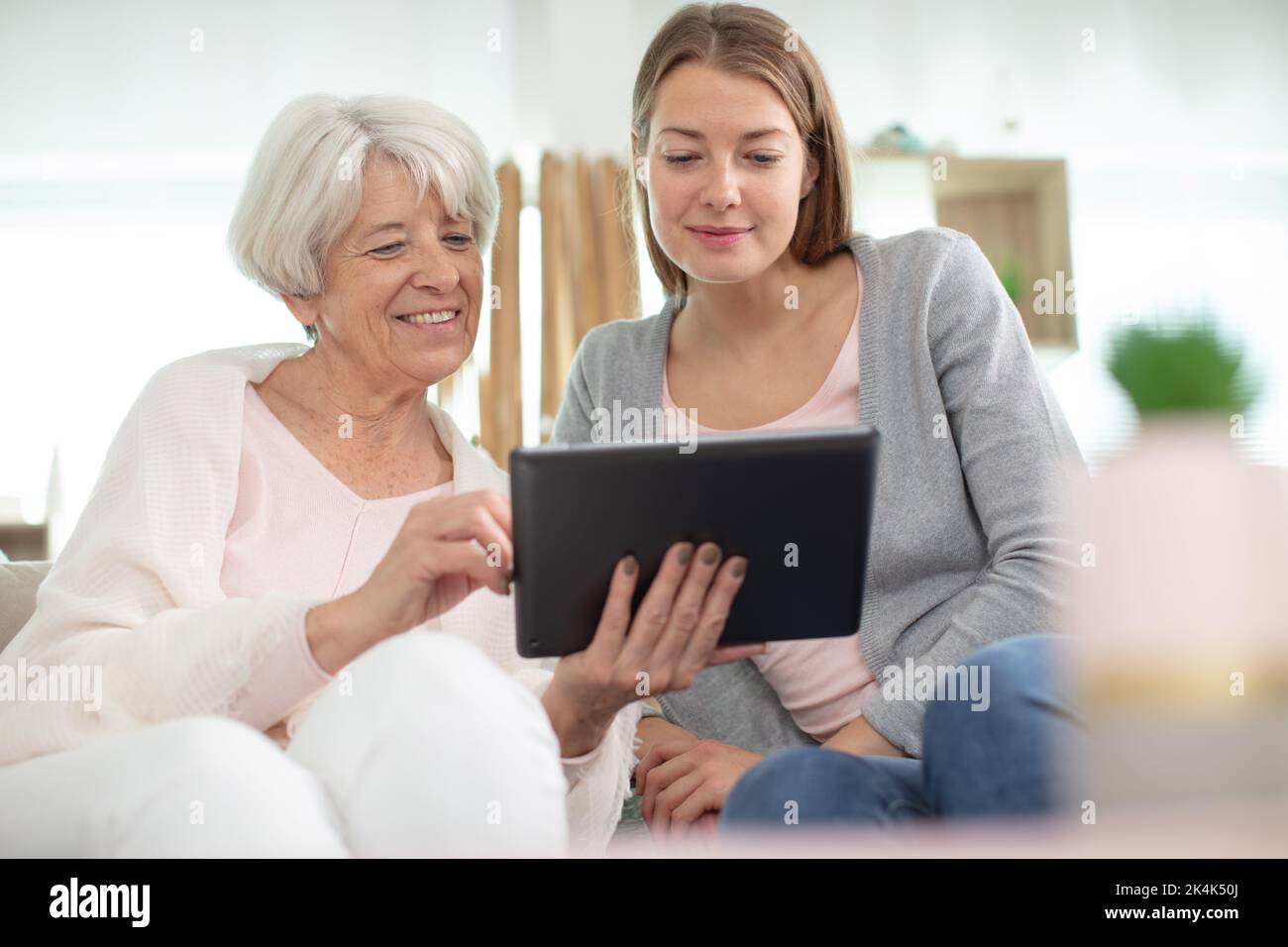 mature mother and her adult daughter using a digital tablet Stock Photo